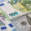 Inversiones. Billetes de 100 euros y de 100 dólares colocados horizontalmente entre una variedad de billetes